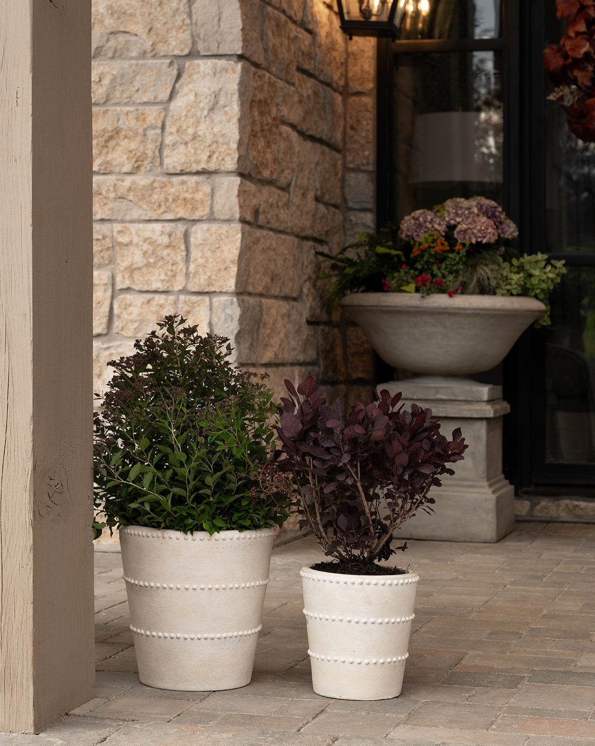 Allston Planter with terracotta finish, shown on a porch in large and small sizes from McGee & Co.

